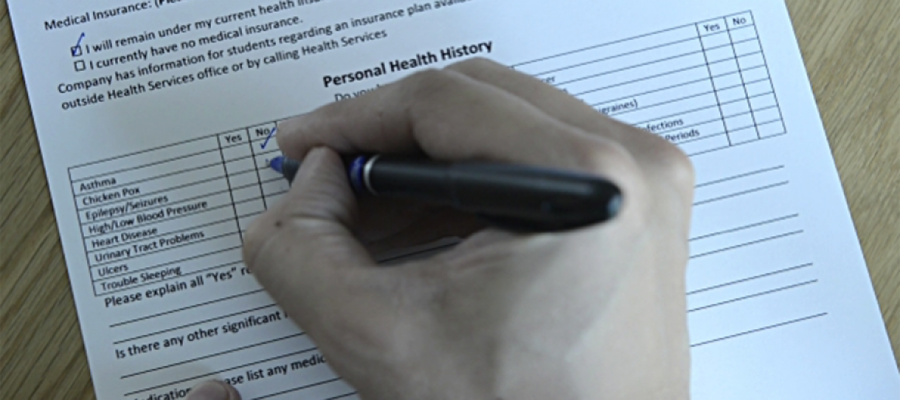 person filling in personal health history form with a pen