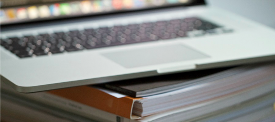 laptop on a pile of reports