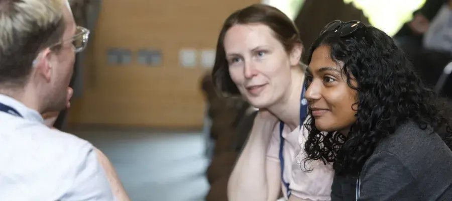 three colleagues in conversation at a conference