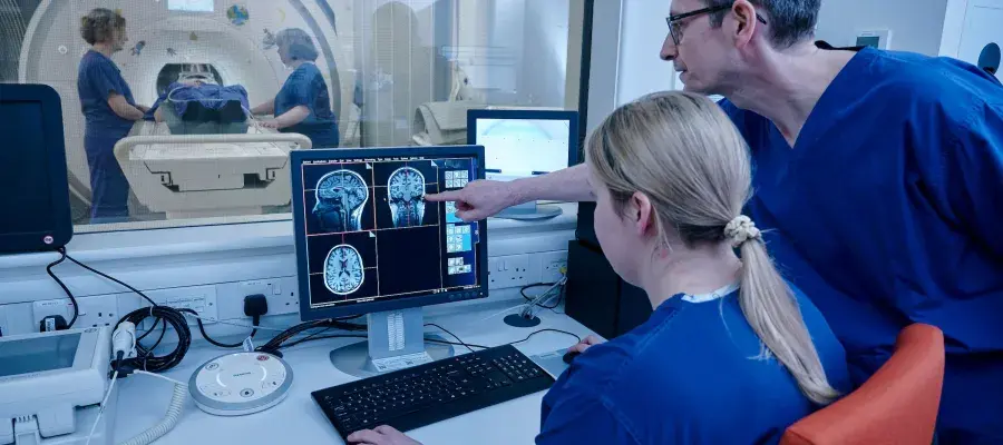 Clinicinas observing brain activity from an MRI scan in the other room