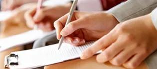 people writing on papers and clipboards