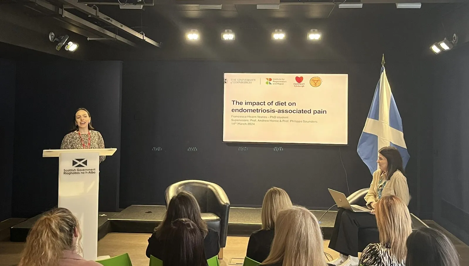 Frankie Hearn-Yeates (PhD student) delivers a presentation in a lecture hall.