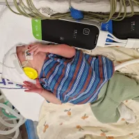 Baby in hospital cot being monitored