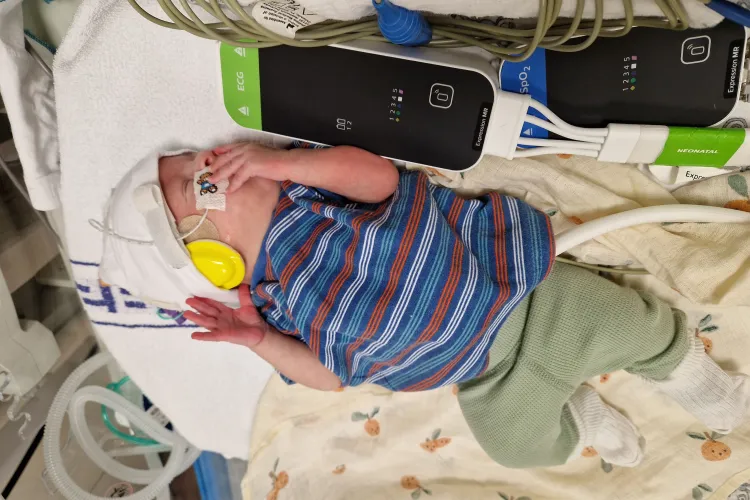 Baby in hospital cot being monitored